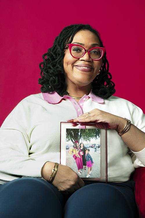 Kelly sitting and holding a photo of her with her children