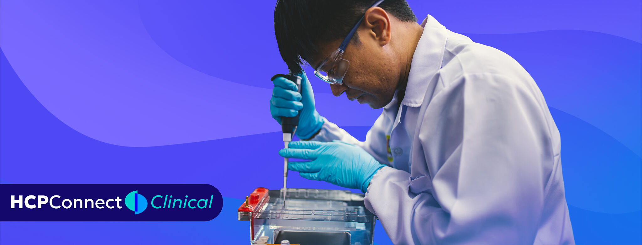 A lab technician uses a micropipette to load samples into an electrophoresis tray.